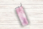 Preview: Ein rosa Thermobecher mit einem eleganten Schneeflockenmotiv, 590 ml Fassungsvermögen, schräg auf hellem Holzuntergrund platziert.